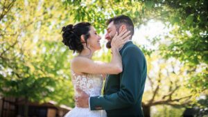 Delphine et Kevin s'enlacent tendrement dans un cadre verdoyant et ensoleille.