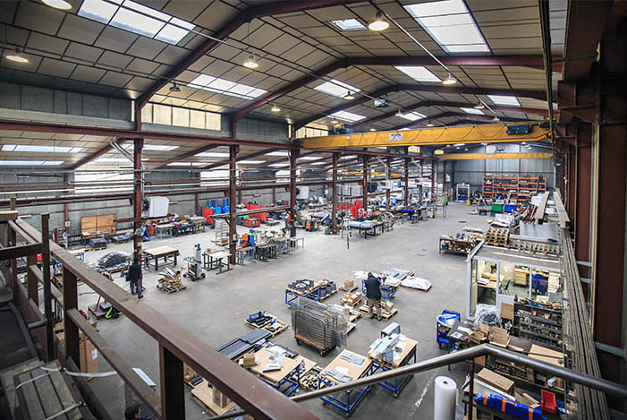 Vue d'un grand atelier industriel avec des postes de travail et une grue surélevée — photographie industrielle à Mâcon