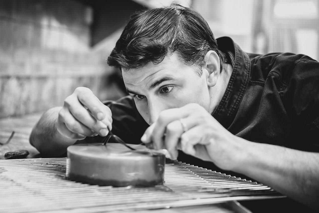 Chef culinaire en train de glacer un cake sur grille métallique — photo culinaire à Mâcon