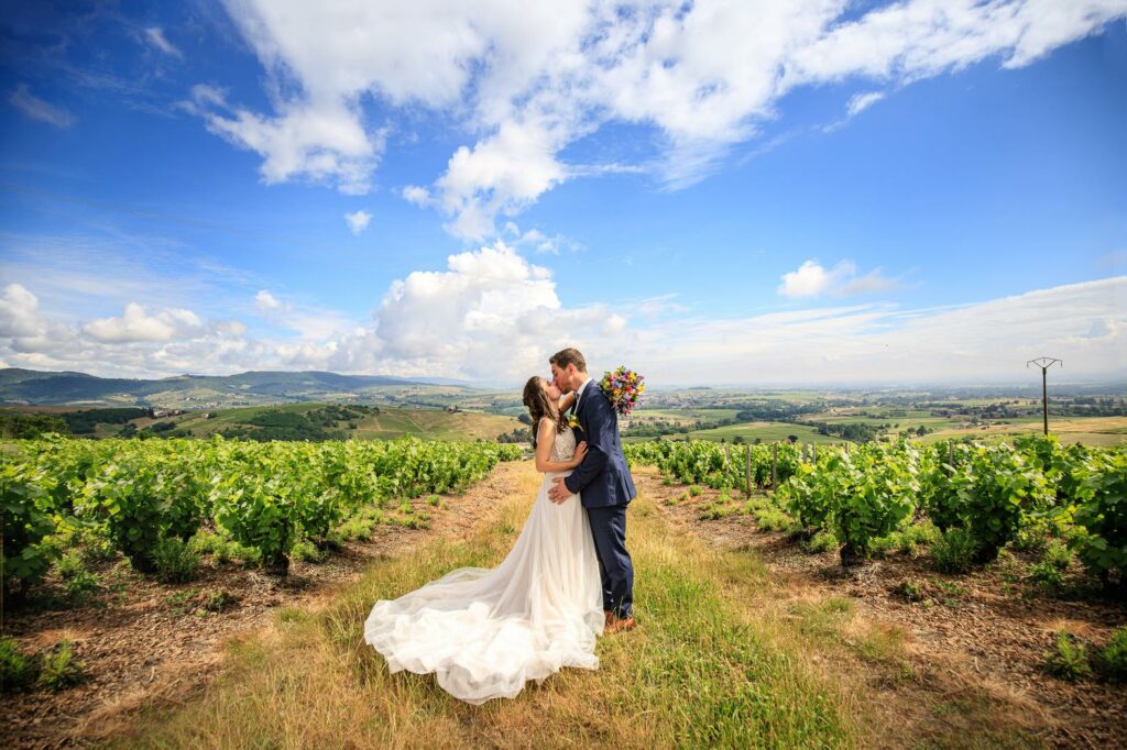 Mariés s'embrassant face à un panorama de vignes — photographe de mariage à Paray-le-Monial