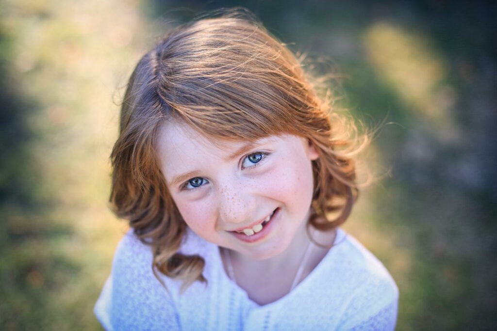 Portrait naturel d'une petite fille souriante en lumière douce — photographe de famille à Paray-le-Monial