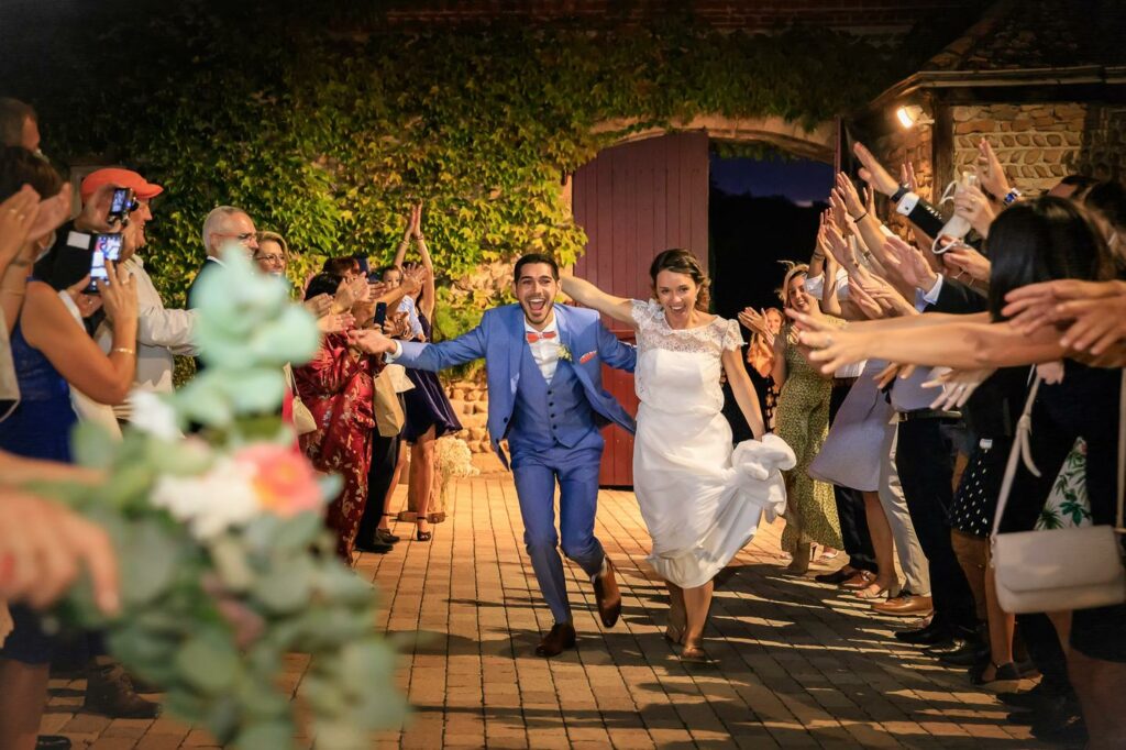 Sortie des mariés acclamés par leurs invités en soirée — photographe de mariage à Paray-le-Monial