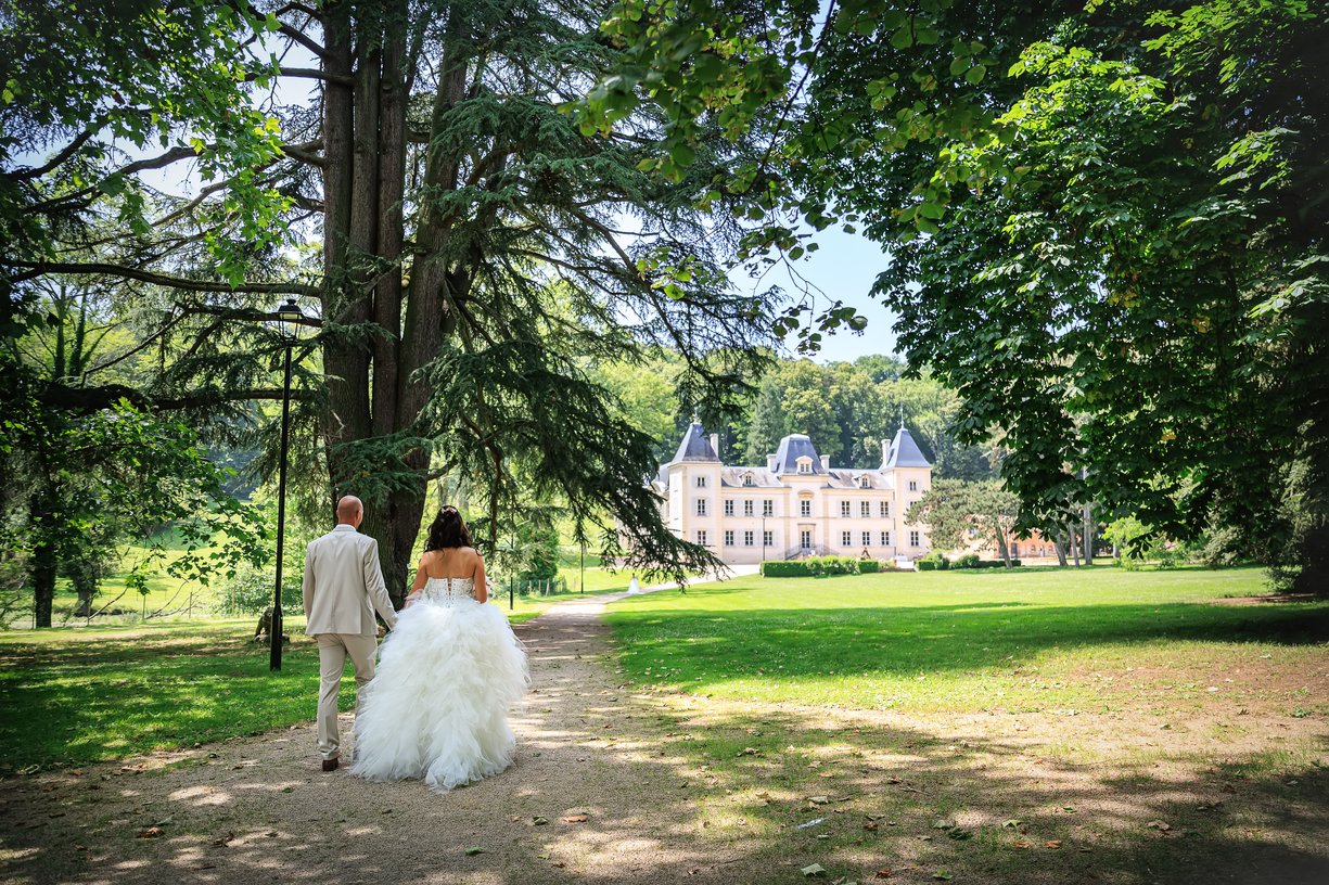Couple de mariés marchant dans le parc du château vers le Tinaillé à Azé