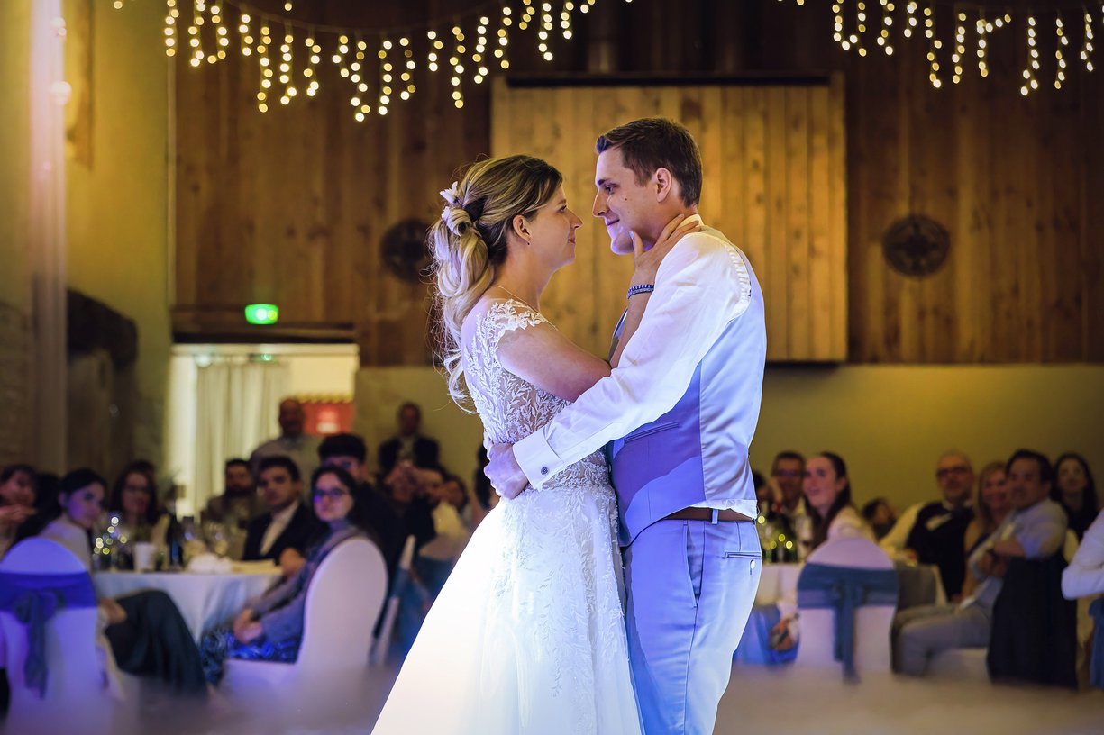 Amandine et Vincent front contre front pendant leur premiere danse, invites attables autour de la piste