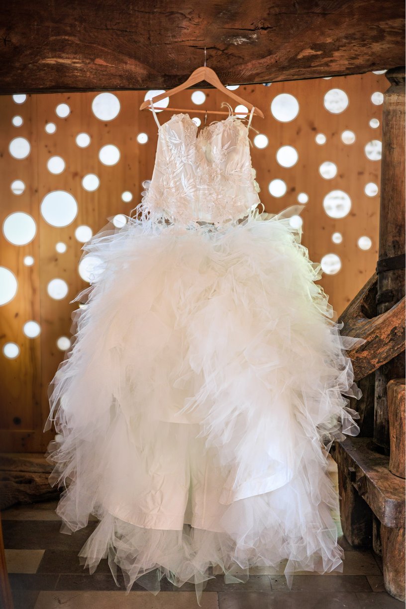 Robe de mariée à volants suspendue devant un mur à pois au Tinaillé à Azé