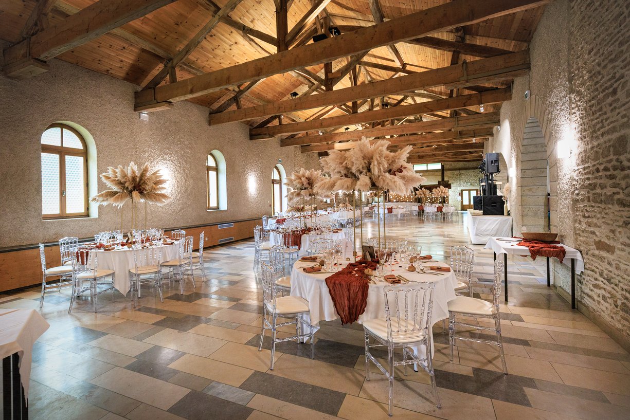 Salle de reception du Tinaille avec poutres apparentes et tables dressees