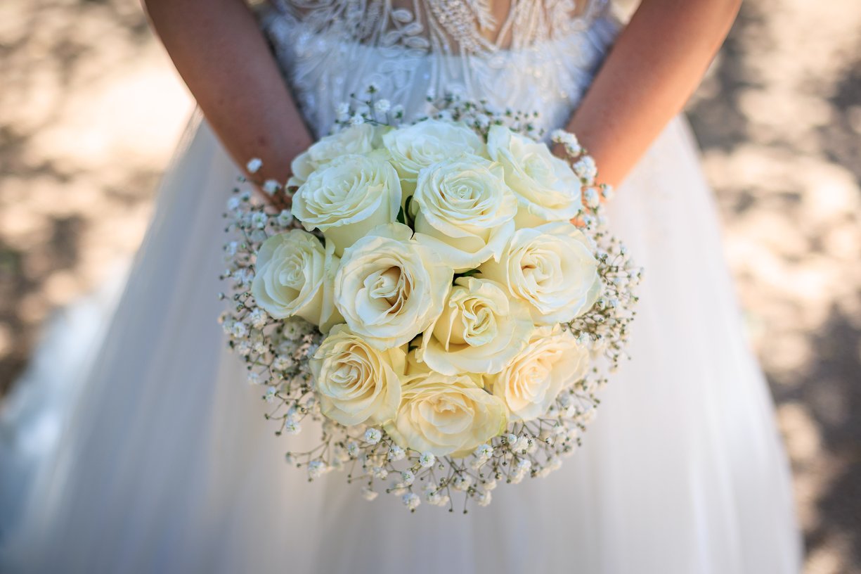 Bouquet de roses blanches et de gypsophile tenu par Camille