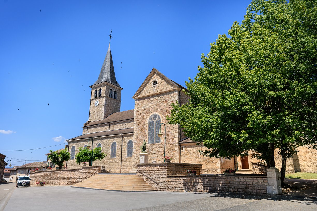 Facade de l'eglise de Feillens, cloche pointu en pierre, ciel bleu, avant l'arrivee des maries